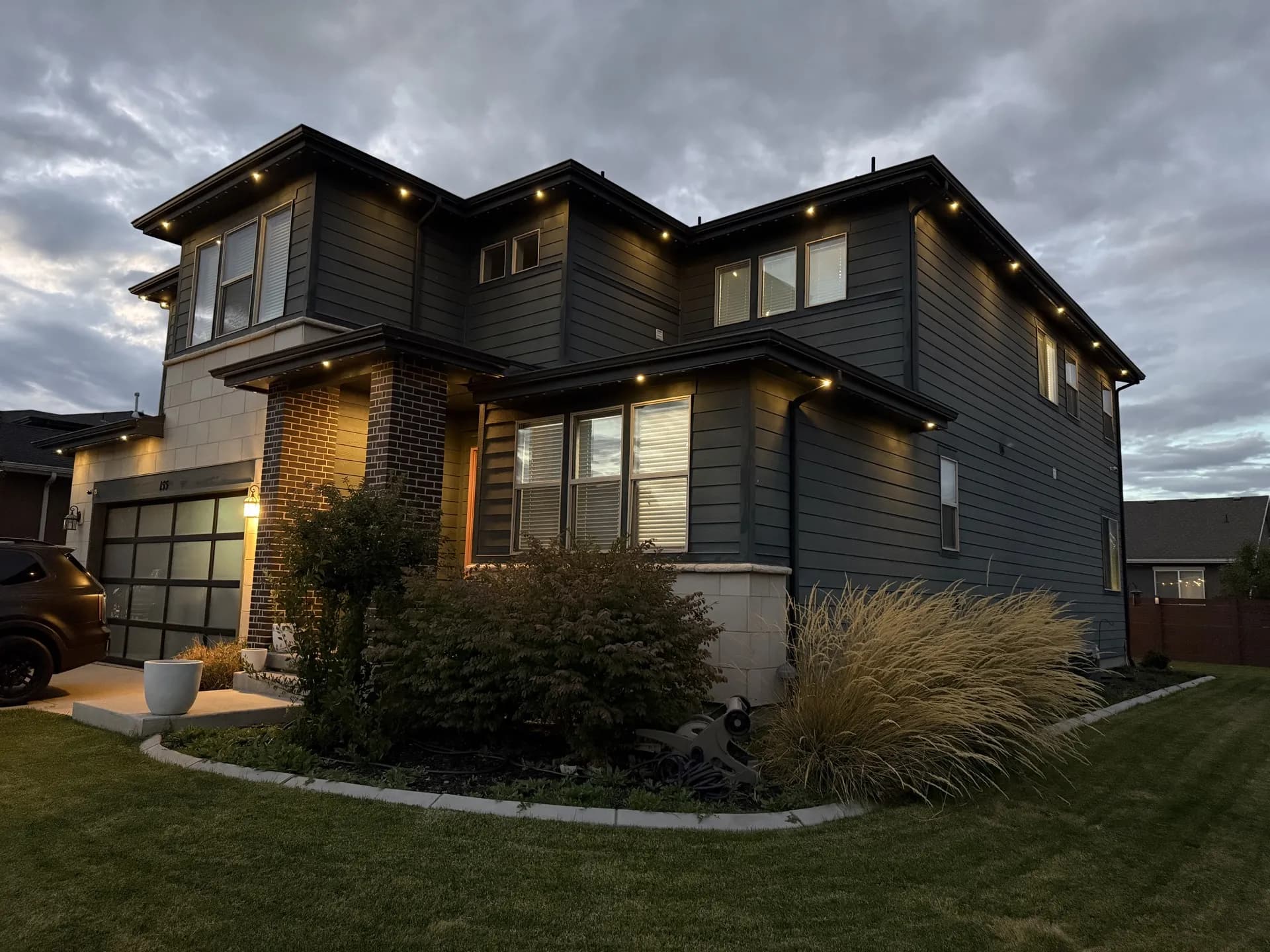 Home with permanent LED outdoor lighting along multiple rooflines at night