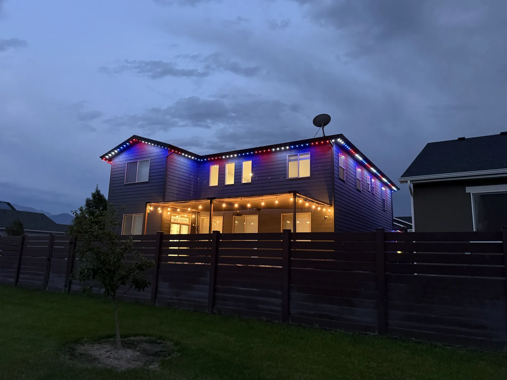 Two-story home with permanent LED lighting highlighting architectural details